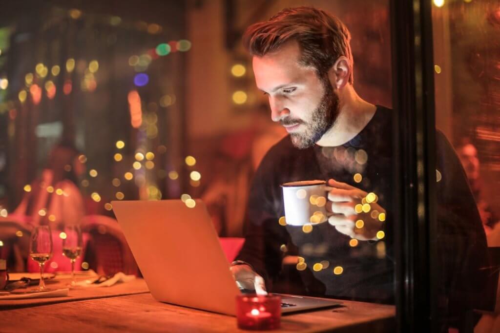 Site institucional: o que é e por que sua empresa precisa 1 Rapaz acessando site institucional no notebook